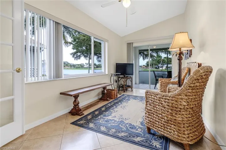 Sitting room with lofted ceiling, tile patterned floors, and ceiling fan