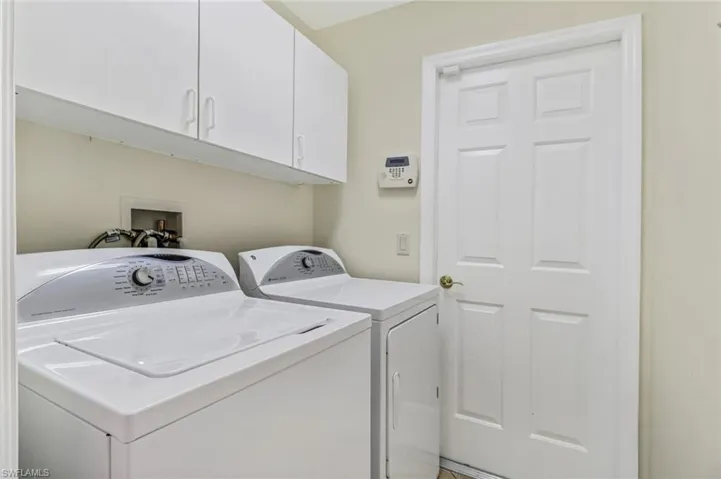 Clothes washing area with cabinets and separate washer and dryer