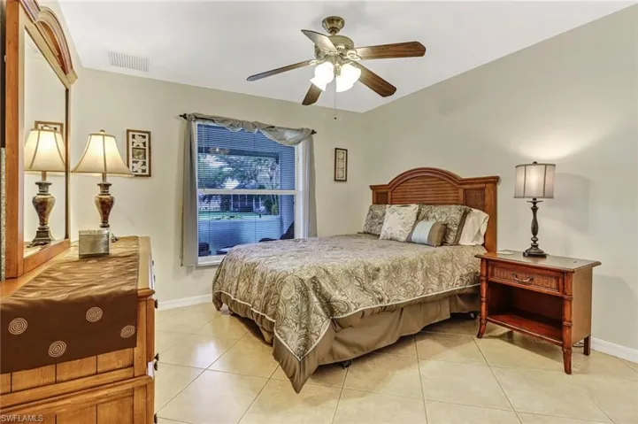 Tiled bedroom featuring ceiling fan