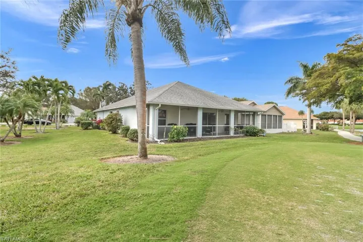 Back of property featuring a lawn and a sunroom