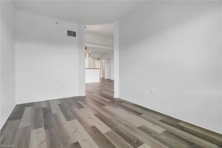 Unfurnished room featuring a notable chandelier and hardwood / wood-style flooring