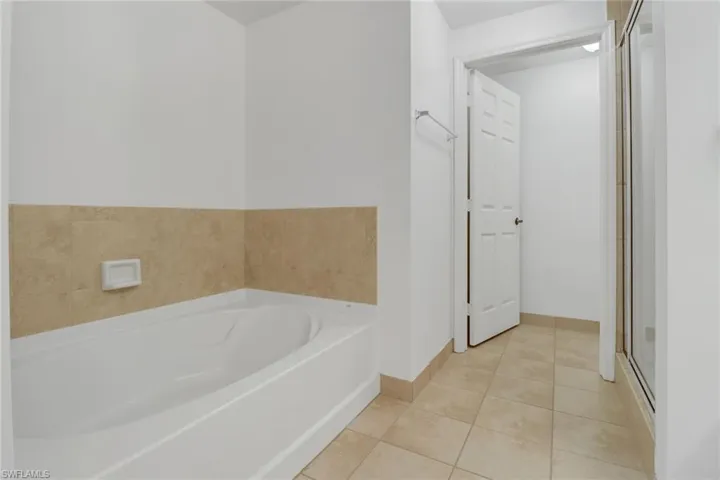 Bathroom featuring independent shower and bath and tile patterned flooring