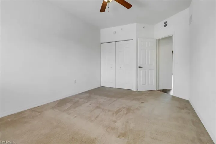 Unfurnished bedroom with carpet, a closet, and ceiling fan