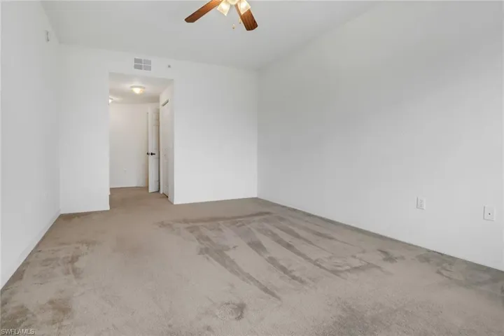 Carpeted spare room with ceiling fan
