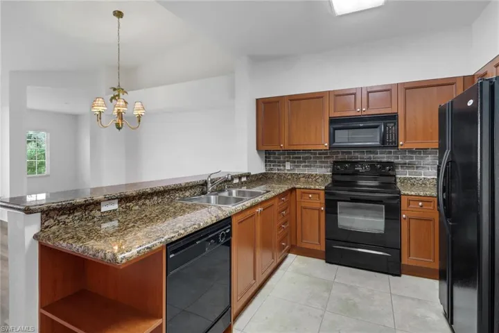 Kitchen featuring sink, kitchen peninsula, and black appliances