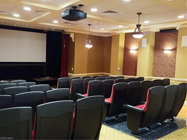 Carpeted home theater with crown molding