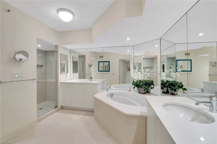 Full bath with a stall shower, light tile patterned floors, a garden tub, two vanities, and recessed lighting