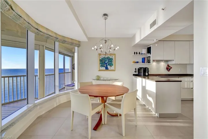Dining space with a water view, a chandelier, and light tile patterned floors