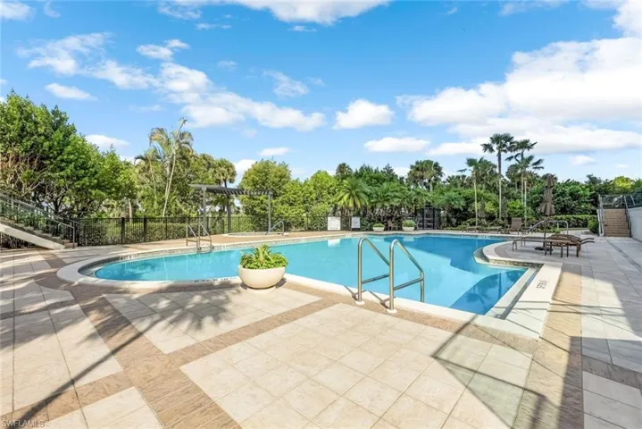 Community pool featuring a patio and view of scattered trees