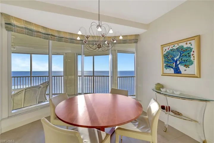 Tiled dining room with a water view and a chandelier