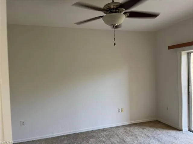 Carpeted empty room featuring ceiling fan