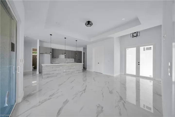 Unfurnished living room with a raised ceiling and french doors