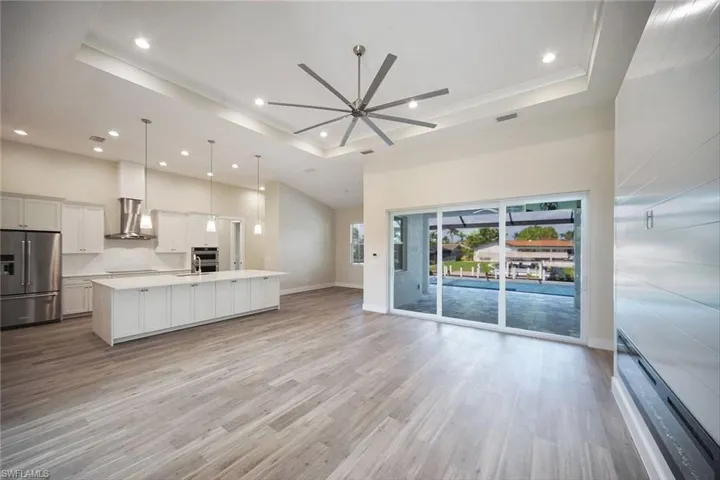 Kitchen with a raised ceiling, high quality fridge, open floor plan, recessed lighting, and a high ceiling