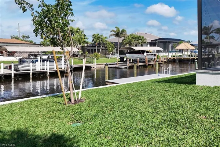 Dock area with a yard, a water view, and boat lift
