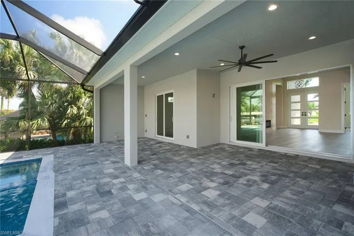 View of patio featuring a ceiling fan, an outdoor pool, glass enclosure, and a sunroom