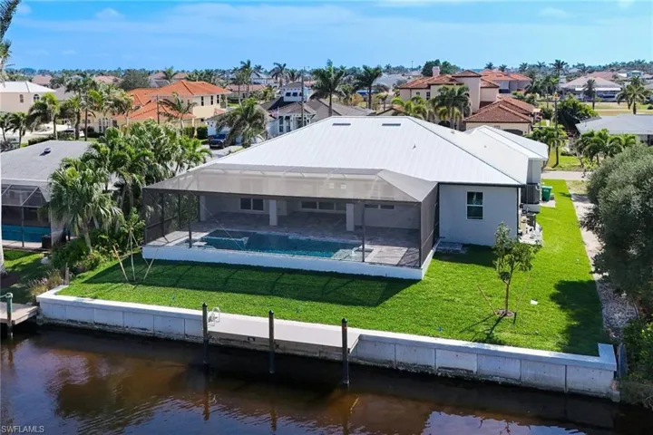 Back of house with a yard, an outdoor pool, a water view, a residential view, and a lanai