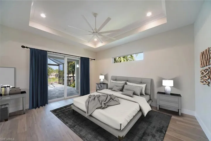 Bedroom featuring a tray ceiling, access to exterior, ceiling fan, and recessed lighting - virtually staged