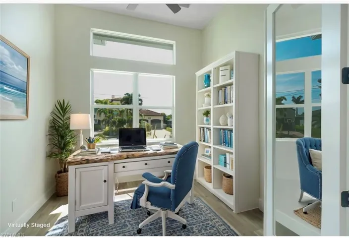Office with wood finished floors and ceiling fan - virtually staged