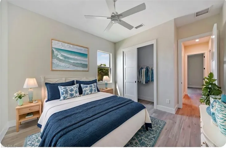 Bedroom with light wood-style floors, a closet, and ceiling fan - virtually staged