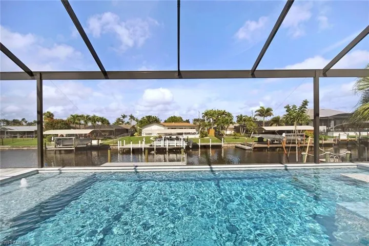 Swimming pool with a water view, a sunroom, and a dock
