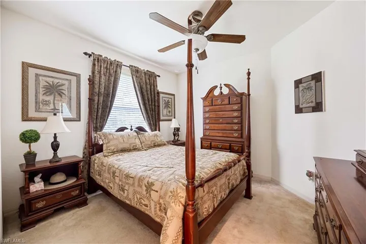 Bedroom with light colored carpet and a ceiling fan