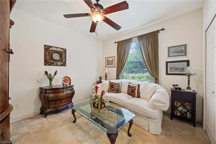 Living room featuring light carpet and a ceiling fan