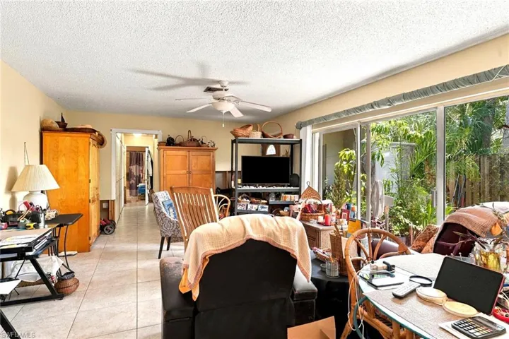 Interior space featuring tile flooring, ceiling fan with integrated lighting, and a large multi-panel sliding glass door