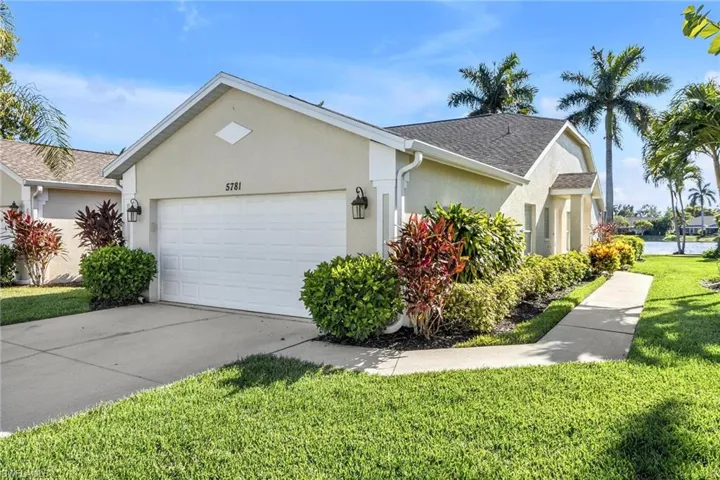 View of front of property with a garage and a front lawn
