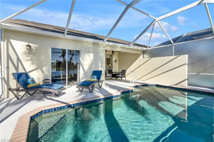 View of pool featuring a patio and covered lanie.  Note sliding door access to Primary Bedroom