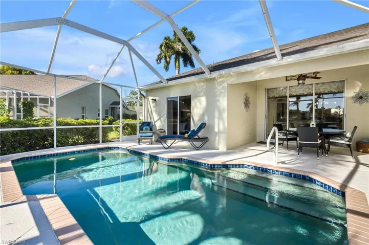 View of pool with a patio, ceiling fan, and glass enclosure