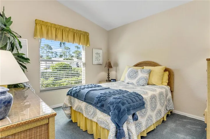 Carpeted bedroom featuring vaulted ceiling