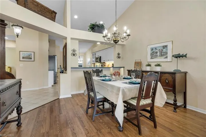 Dining area with high vaulted ceiling, an inviting chandelier, and LVP flooring.