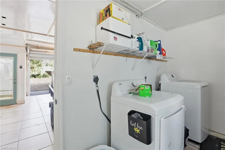 Laundry room featuring independent washer and dryer and light tile patterned flooring - Virtually Edited Image