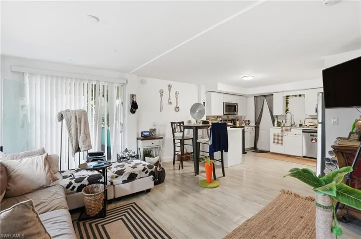 Living room featuring light wood finished floors and baseboards - Virtually Edited Image