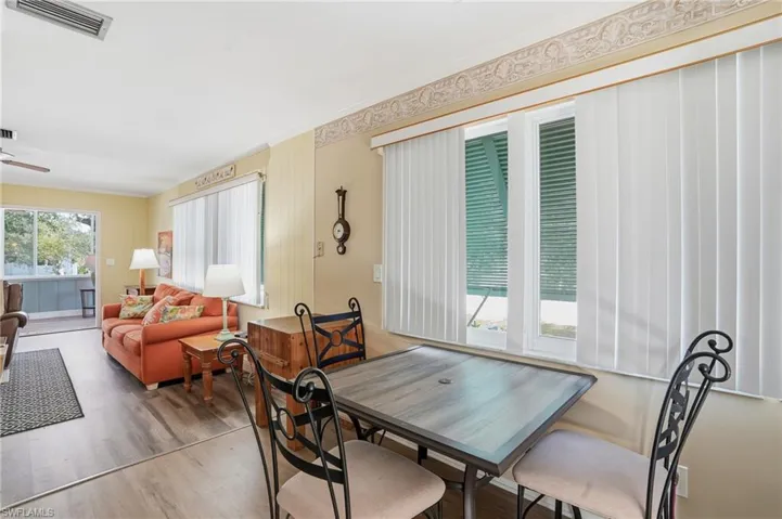 Dining area featuring wood finished floors, a ceiling fan, and ornamental molding - Virtually Edited Image