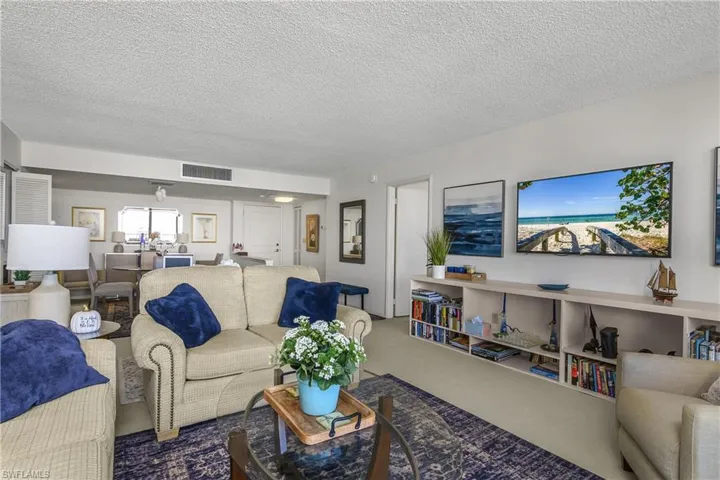Carpeted living room featuring a textured ceiling