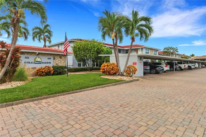 View of front of property featuring a front lawn and covered parking