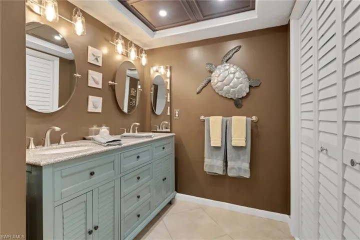Full bathroom with a closet, double vanity, and light tile patterned flooring