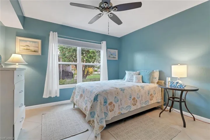Bedroom with light tile patterned floors and a ceiling fan