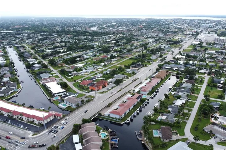 Aerial view of property and surrounding area with a nearby body of water and nearby suburban area