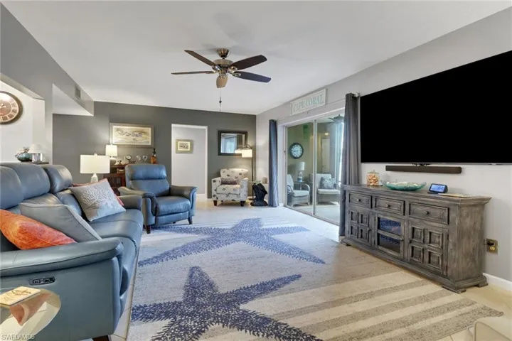 Living area with light tile patterned flooring and ceiling fan