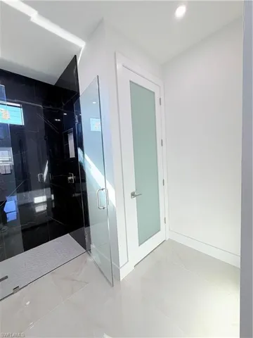 Bathroom featuring a marble finish shower and recessed lighting