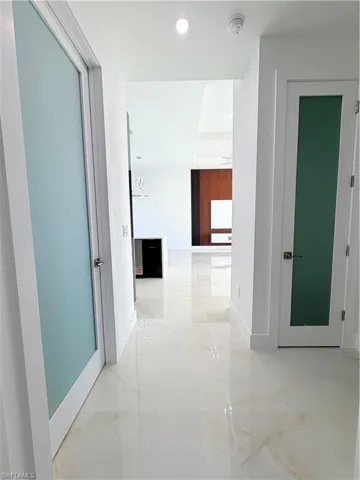 Corridor with recessed lighting and light marble finish flooring