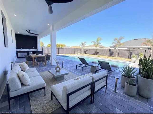 Fenced backyard with a ceiling fan, a patio area, and outdoor lounge area