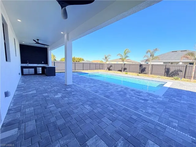 View of pool with patio surround, a fenced backyard, and area for grilling