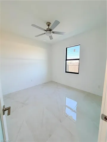 Spare room featuring baseboards and ceiling fan