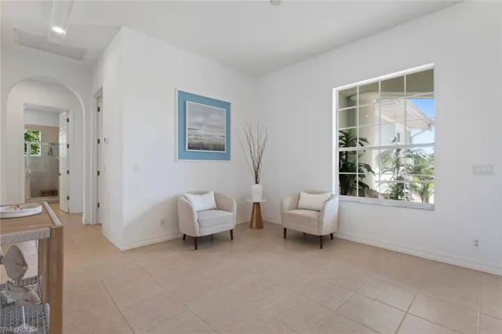 Living area with light tile patterned floors and arched walkways