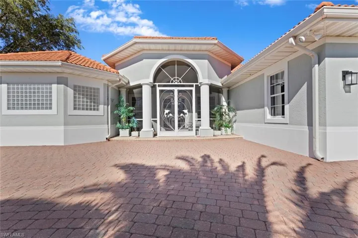 Doorway to property featuring stucco siding, a tiled roof, and a patio area