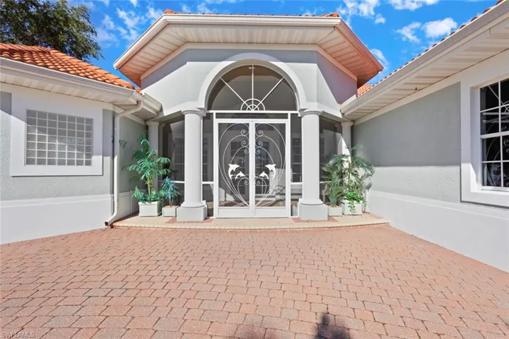 Entrance to property with stucco siding, a sunroom, french doors, a tile roof, and a patio area