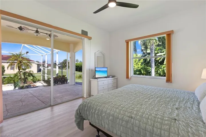 Bedroom with wood finished floors, a ceiling fan, and access to exterior